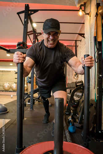 Determinant man with disability pushing weights in gym photo