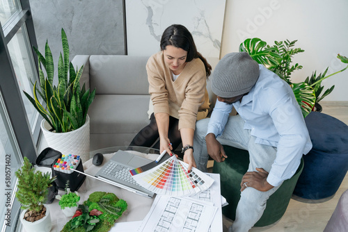 Architect discussing with colleague over color swatches at workplace photo