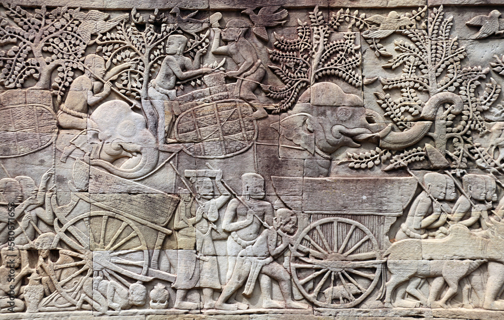 Wall carving of Prasat Bayon Temple in famous landmark Angkor Wat complex, Siem Reap, Cambodia. Bas-relief depicting women, child, bulls, elephants