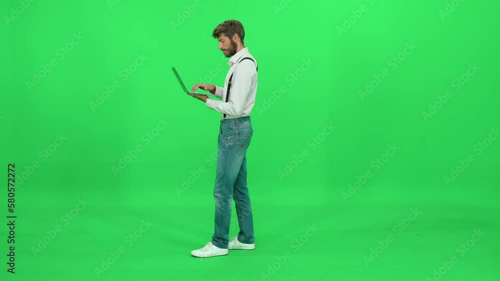 Art director works on a laptop, typing and uses laptop on the go, green background, chroma key template. Art director works on a laptop, typing and uses laptop on the go, green background, chroma key template.
