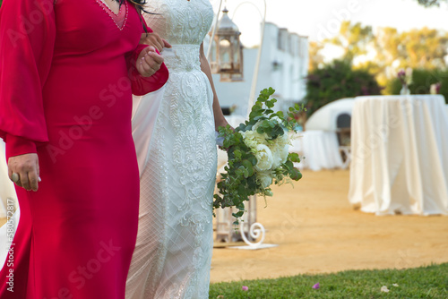 Foto Detail of the bride's bouquet on the arm of her godmother before the wedding ceremony