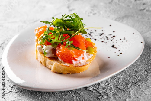 Bruschetta with salmon, cream cheese and arugula on plate