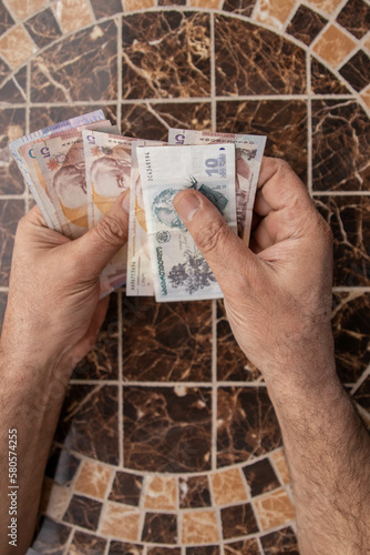 a man counts money at the table. Georgian banknotes in the hands of a tourist. Georgian lari