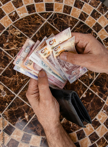 a man counts money at the table. Georgian banknotes in the hands of a tourist. Georgian lari