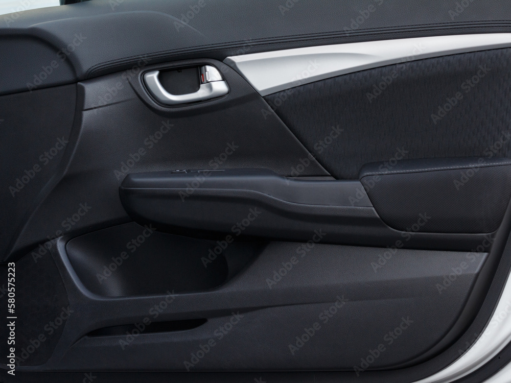 Modern car door panel close-up view. Door lock opening switches