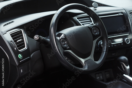 Modern business car interior with dashboard panel and steering wheel. Driver seat view. © Andrey Myagkov