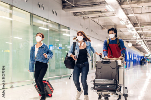 Young friend traveler in quarantine for coronavirus wearing surgical mask face protection with luggage flight travel before long travel vacation flight at International terminal airport