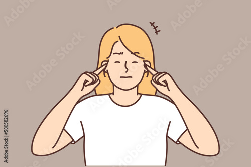 Unhappy woman close ears hearing loud noise 