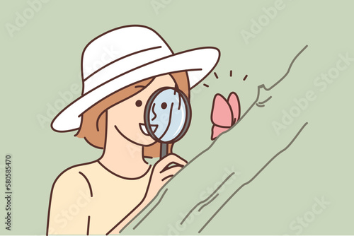 Smiling woman with magnifier look at butterfly