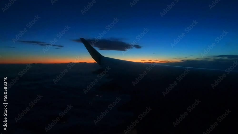 a wing of an airplane with a flashing lantern on the background of sunset in the sky a wing of an airplane with a flashing lantern on the background of sunset in the sky