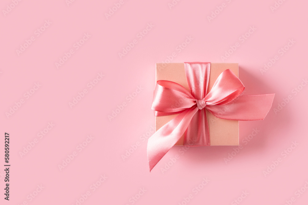 Pink gift box with bow on pink background Pink gift box with bow on pink background