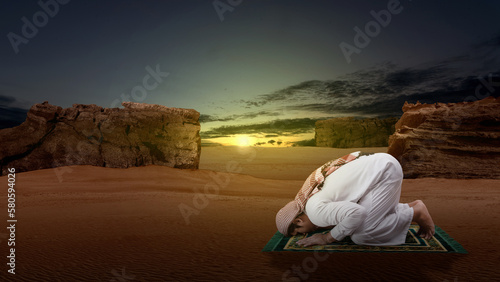 Muslim man with keffiyeh and agal in praying position (salat) on the prayer rug