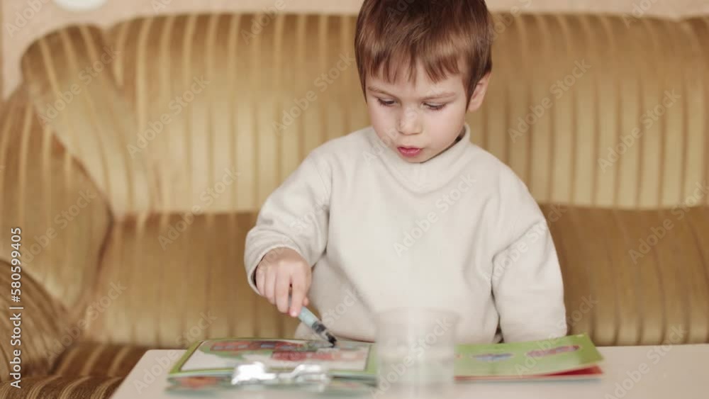 Child boy draws with a water marker Child boy draws with a water marker