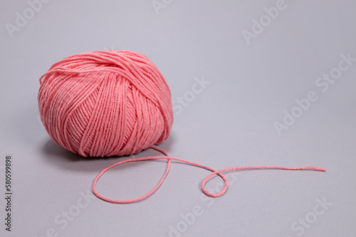 Pink ball of wool on a gray background