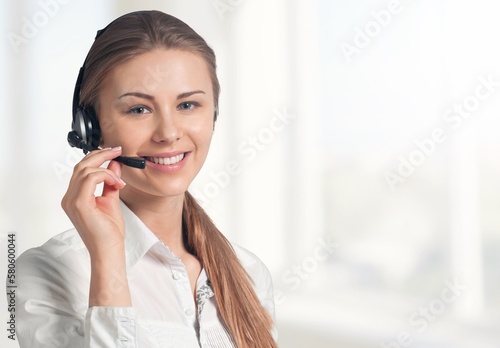 Young woman working wearing a headset in a call centre.