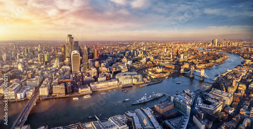 Panoramic sunset view over the skyline of the City of London, England, down the River Thames with Tower Bridge and Canary Wharf district photo