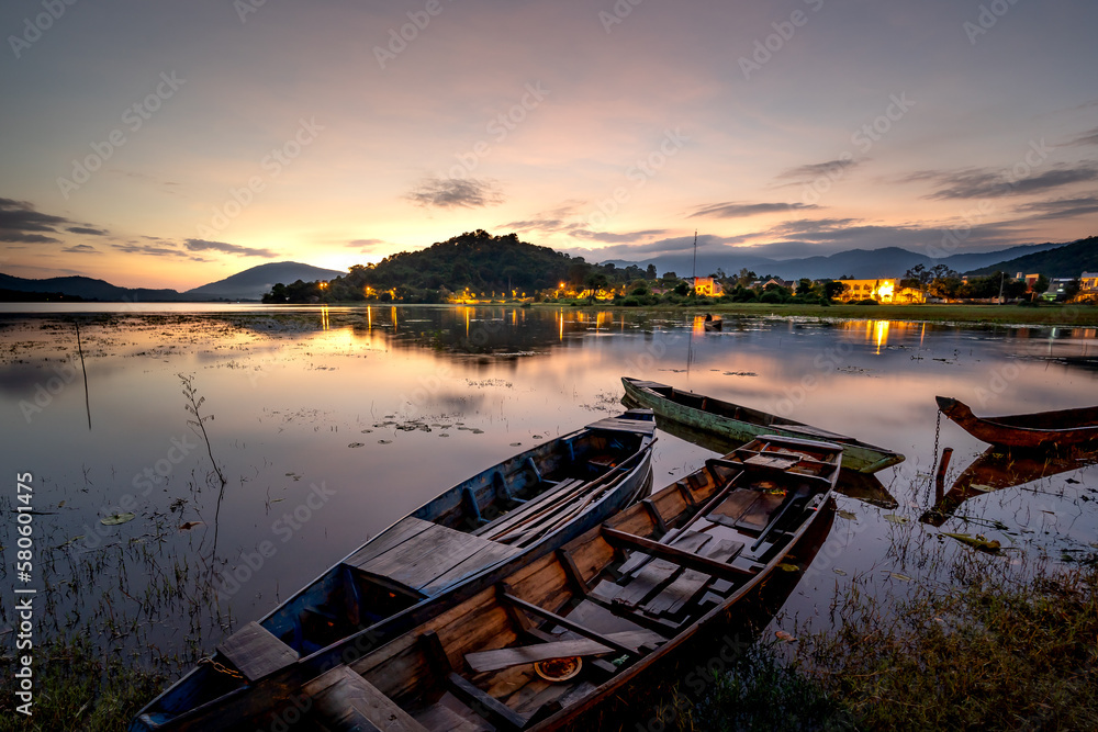 Beautiful sunrise at Lak lake in Buon Ma Thuat, Dak Lak province, Vietnam with a focus on the boat. The concept of feeling lonely