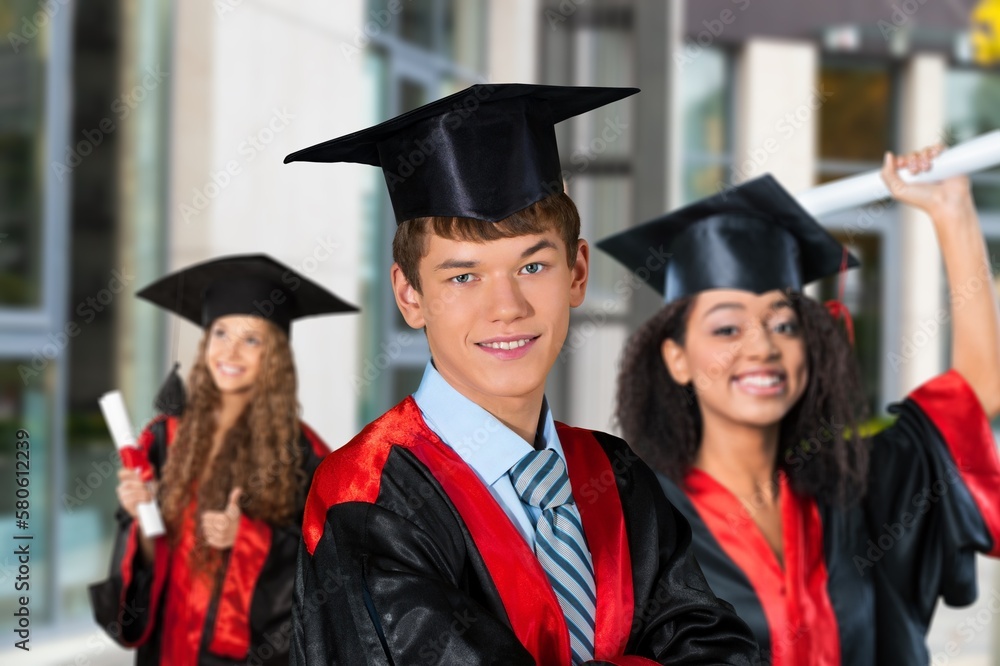 Happy young students in graduation costumes Happy young students in graduation costumes
