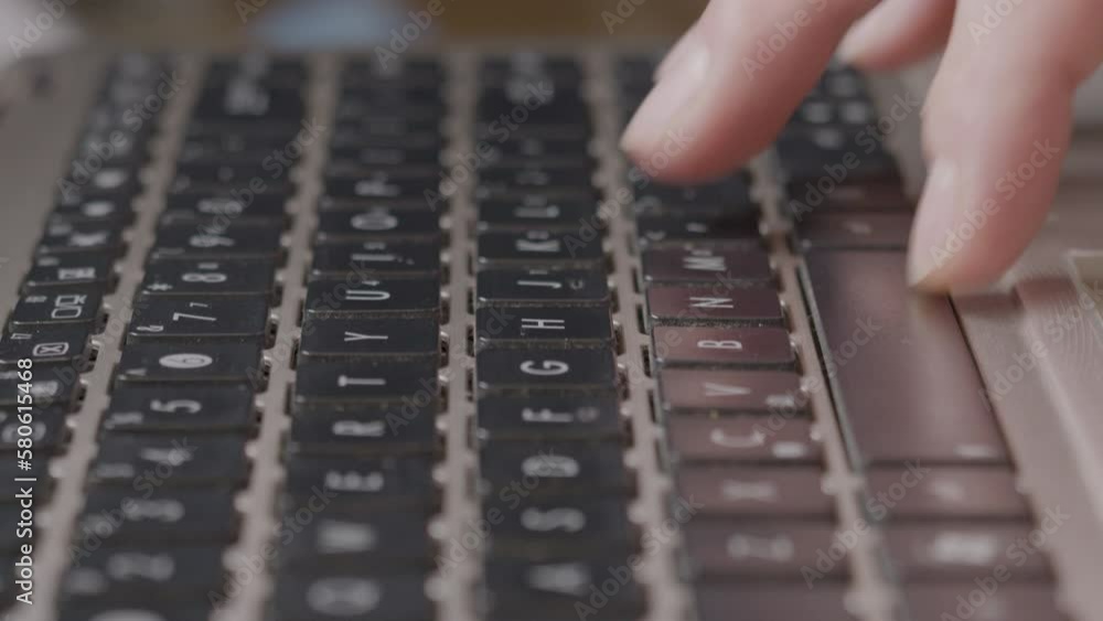 Close-up caucasian finger typing fast on a notebook, dolly backward Close-up caucasian finger typing fast on a notebook, dolly backward