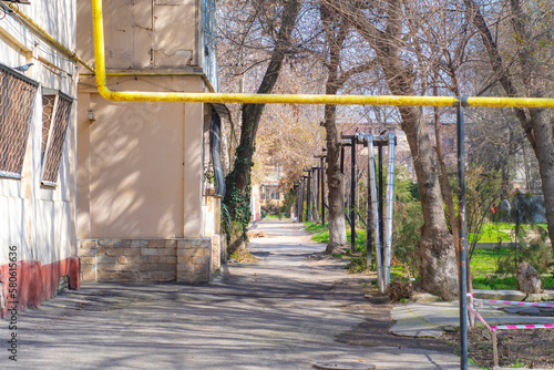 A yellow gas pipe runs over a street in a small poor town in Eastern Europe.
