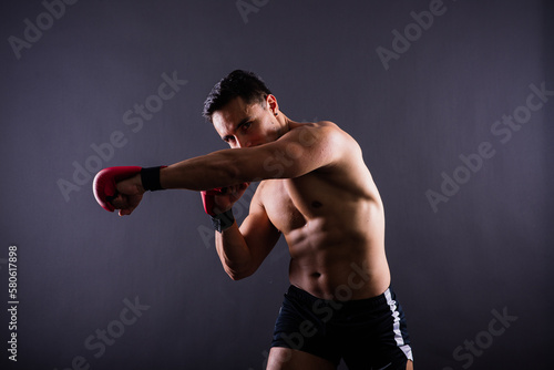 Boxing gloves, man training in sports fight, challenge or mma competition on studio background.