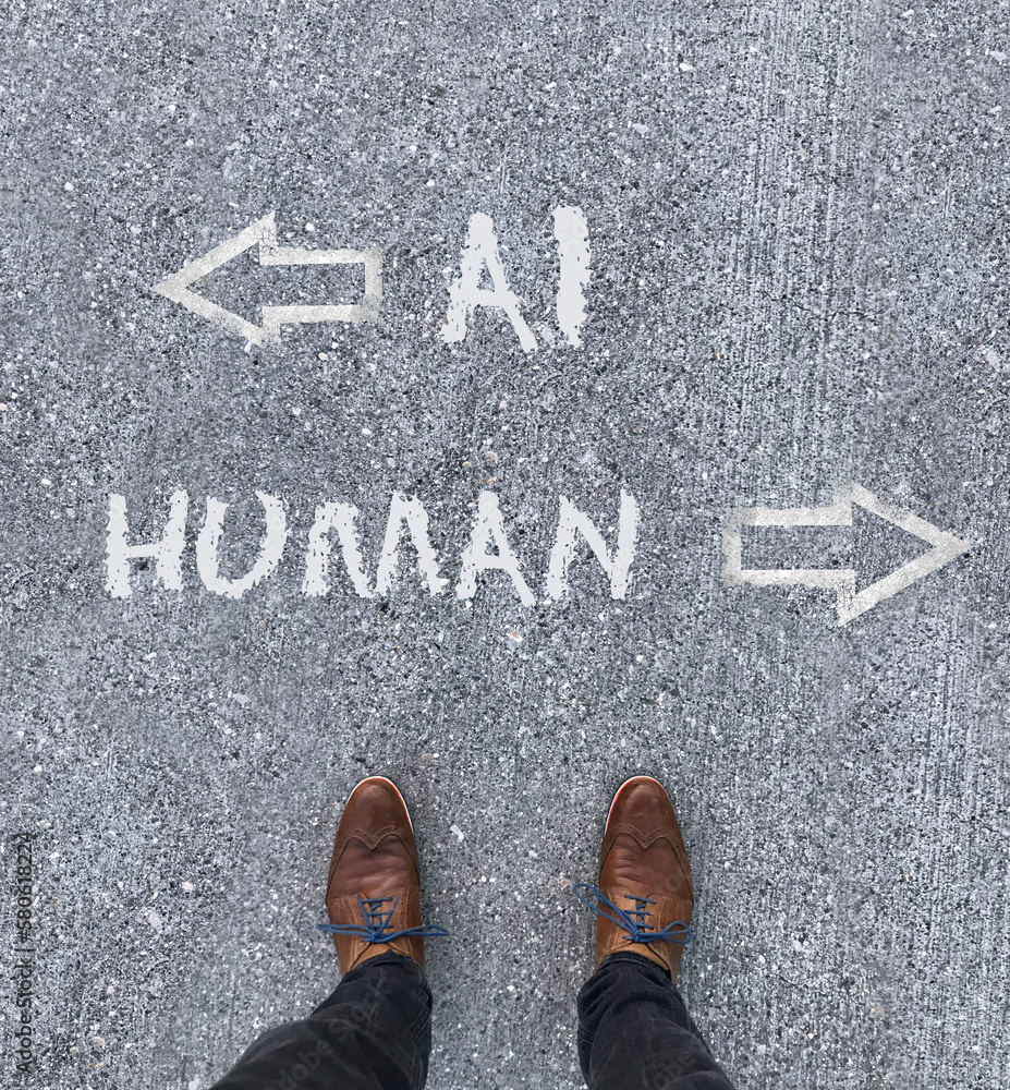 Man looking down at the words Artificial Intelligence - AI - and Human chalked onto the floor Man looking down at the words Artificial Intelligence - AI - and Human chalked onto the floor
