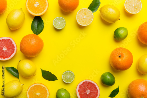 Flat lay of citrus fruits like lime  orange and lemon with lemon tree leaves on light colored background making a frame. Space for text healthy concept
