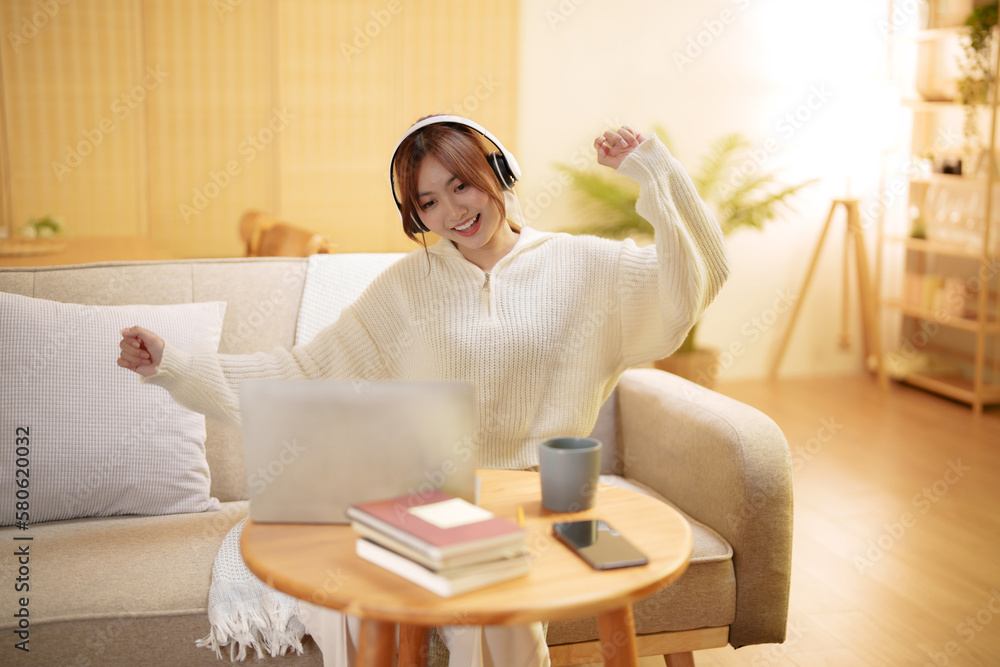 Young asian woman with headphones relaxing at home. listening to music Young asian woman with headphones relaxing at home. listening to music