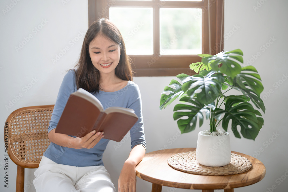 .Young asian woman reading a book at home, girl hold book Education school university college concept.concept. .Young asian woman reading a book at home, girl hold book Education school university college concept.concept.