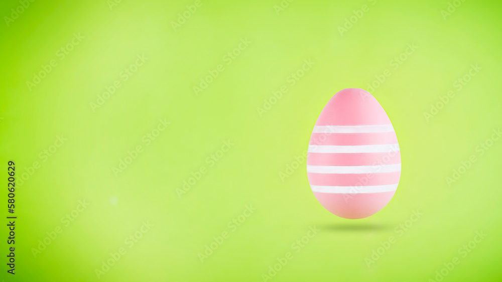 Pink easter egg levitating on green background. Easter background with copy space Pink easter egg levitating on green background. Easter background with copy space