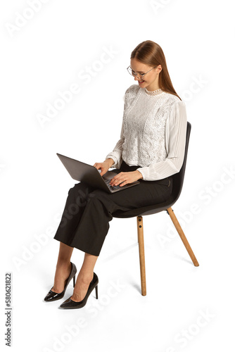 Portrait of young person, worker, student sitting and using laptop isolated over white background. Concept of business, office lifestyle, success, career, finance, ad