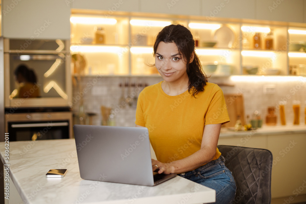 Close up. Happy indian or arabian young woman working by laptop at home Close up. Happy indian or arabian young woman working by laptop at home