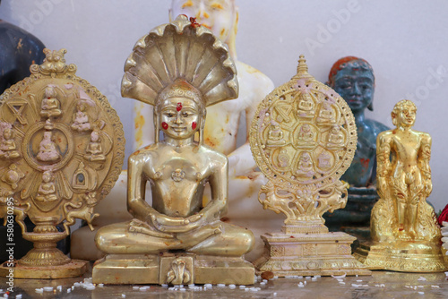 A Close up picture of Lord Parashwanath Tirthankara statue in gold metal at a Jain pilgrimage in Karnataka, India.
 photo
