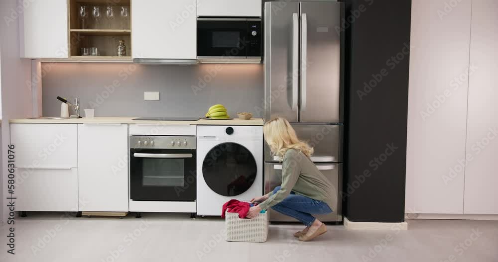 Woman Loading Dirty Clothes In Washing Machine For Washing Woman Loading Dirty Clothes In Washing Machine For Washing
