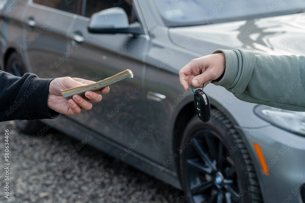 Deal of buying or renting car concept. Hand with car keys, other hand gives money. Deal of buying or renting car concept. Hand with car keys, other hand gives money.