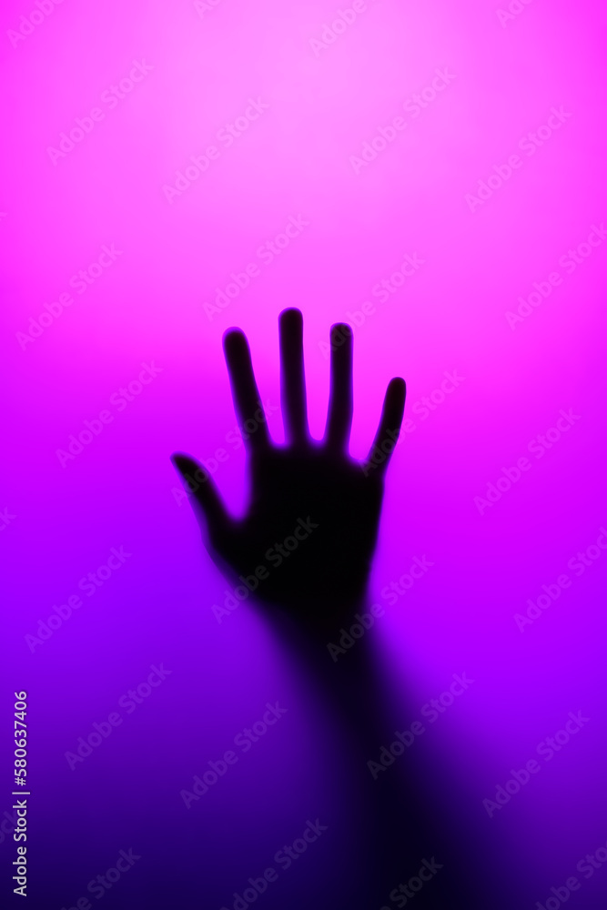 Silhouette of an open palm in neon light