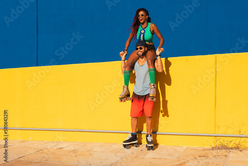 Cheerful couple with roller skating outside. Fun sexy boyfriend and girlfriend enjoy in sunny day..