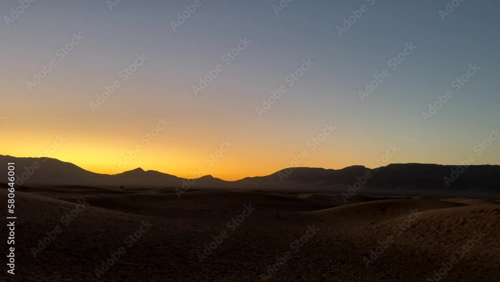 Beautiful scenic desert landscape with orange sunset behind mountains Beautiful scenic desert landscape with orange sunset behind mountains