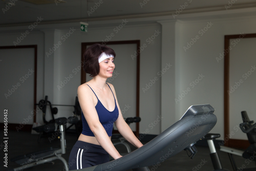 Adult woman on a treadmill gym. Adult woman on a treadmill gym.