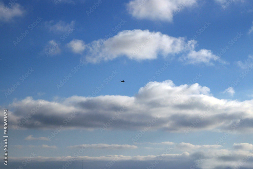 Small helicopter flying in the cloudy sky Small helicopter flying in the cloudy sky