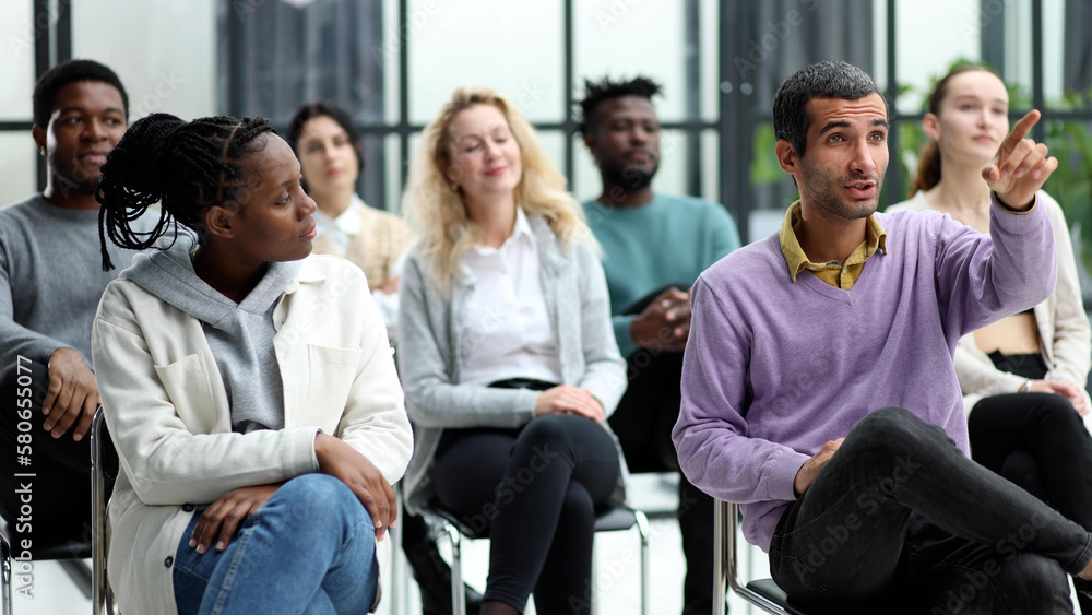 Close-up of people chatting, sitting in a circle and gesturing Close-up of people chatting, sitting in a circle and gesturing