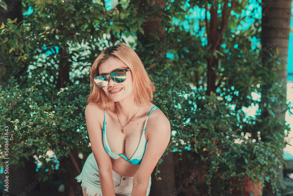 Young asian chrome colored hair in teasing pose with a lush garden backdrop for a summer nature inspired look. Young asian chrome colored hair in teasing pose with a lush garden backdrop for a summer nature inspired look.