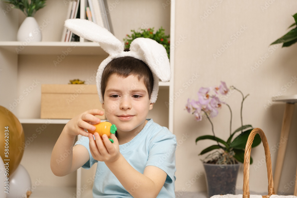 A preschool Easter boy plays with carrots, rabbit ears on his head. A preschool Easter boy plays with carrots, rabbit ears on his head.