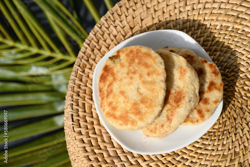 Amazing Sri Lankan three Pol Coconut Roti in white plate. Traditional flat bread with red onion and chilli. View from above. Authentic recipe. Copy space.