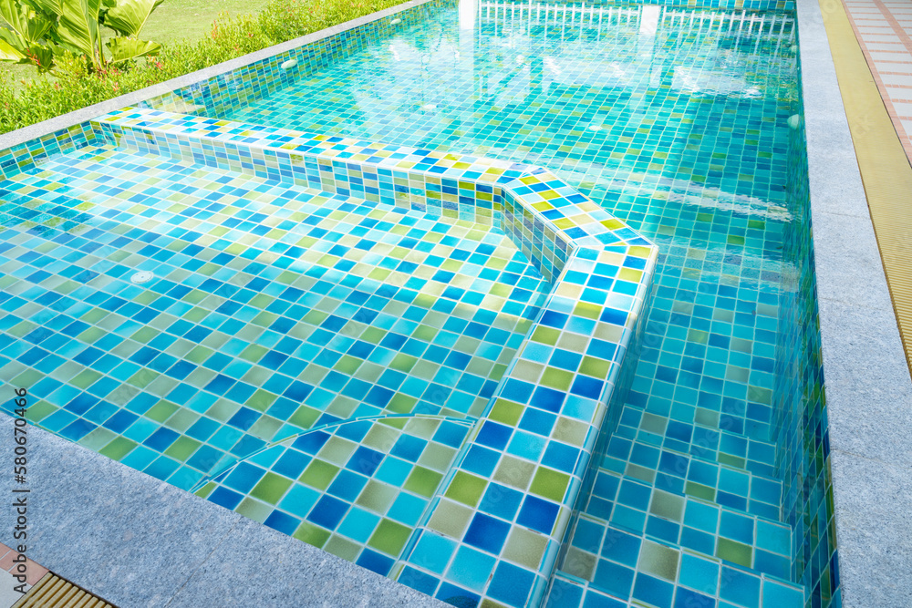 Obraz premium The Macro from Swimming pool with clear blue water in a garden area, surrounded by plants