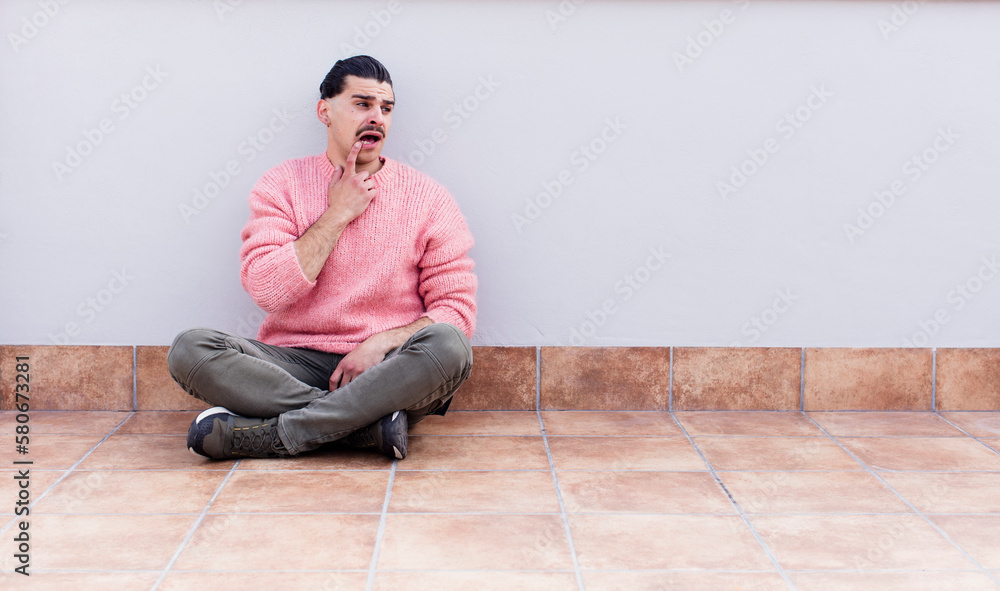 young handsome man sitting on the floors with a copyspace young handsome man sitting on the floors with a copyspace