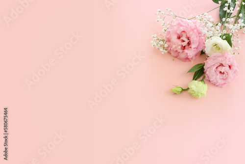 Top view image of delicate pink lisianthus flowers over pastel background © tomertu