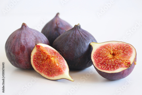 Fresh ripened purple figs. Creative composition, the decorative banner of whole and sliced exotic fruit isolated on white table background. Natural pattern. Flat lay, top view. Food photography.