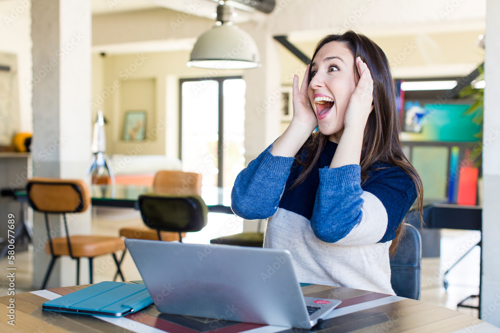 young pretty woman feeling happy, excited and surprised. telecommuting concept young pretty woman feeling happy, excited and surprised. telecommuting concept