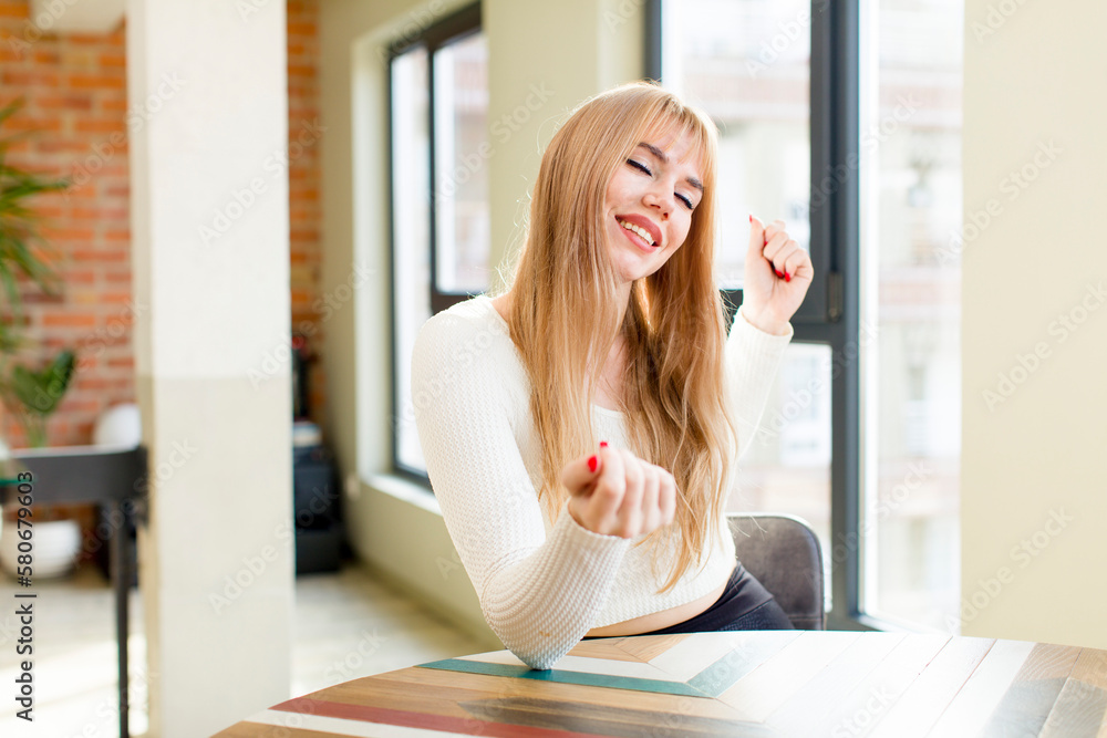 young pretty woman smiling, feeling carefree, relaxed and happy, dancing and listening to music, having fun at a party. home interior young pretty woman smiling, feeling carefree, relaxed and happy, dancing and listening to music, having fun at a party. home interior